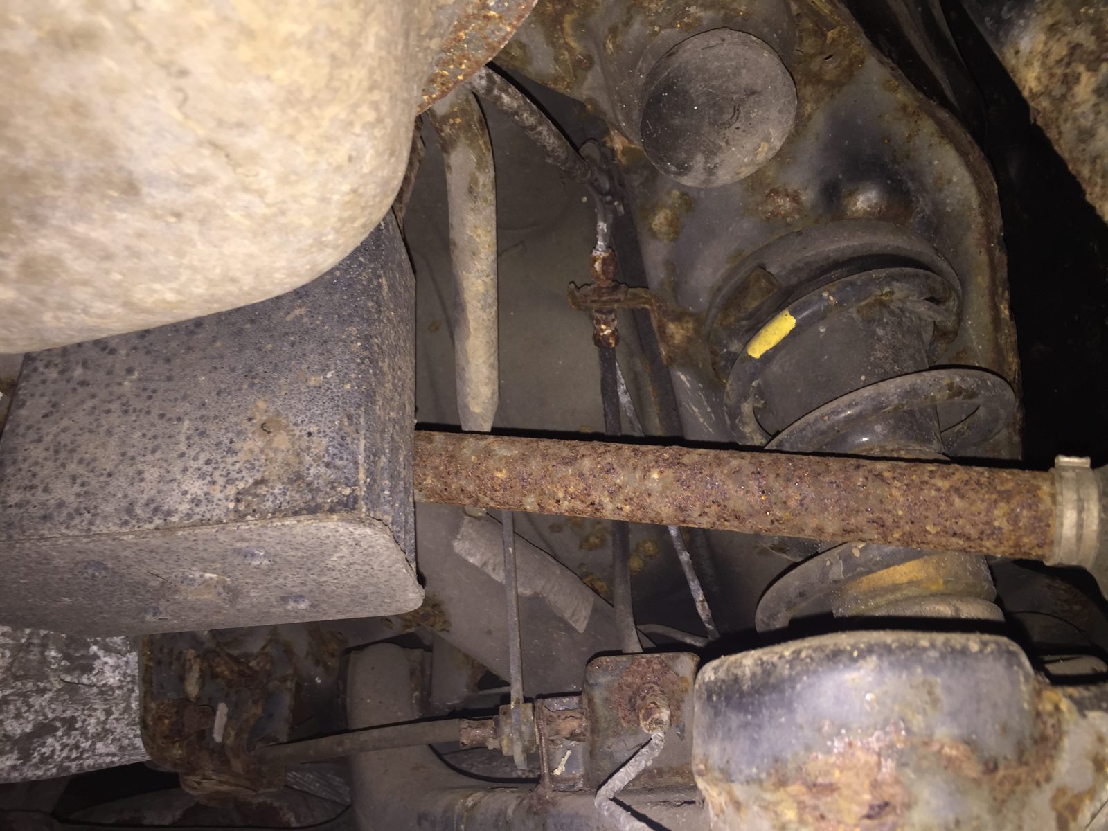 Under the car, with a rusty exhaust and suspension arms