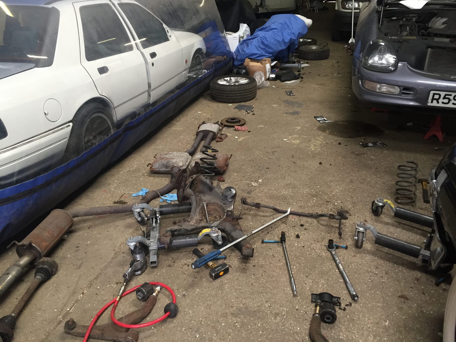 Front hub and brake disc off the car, with tools on the ground