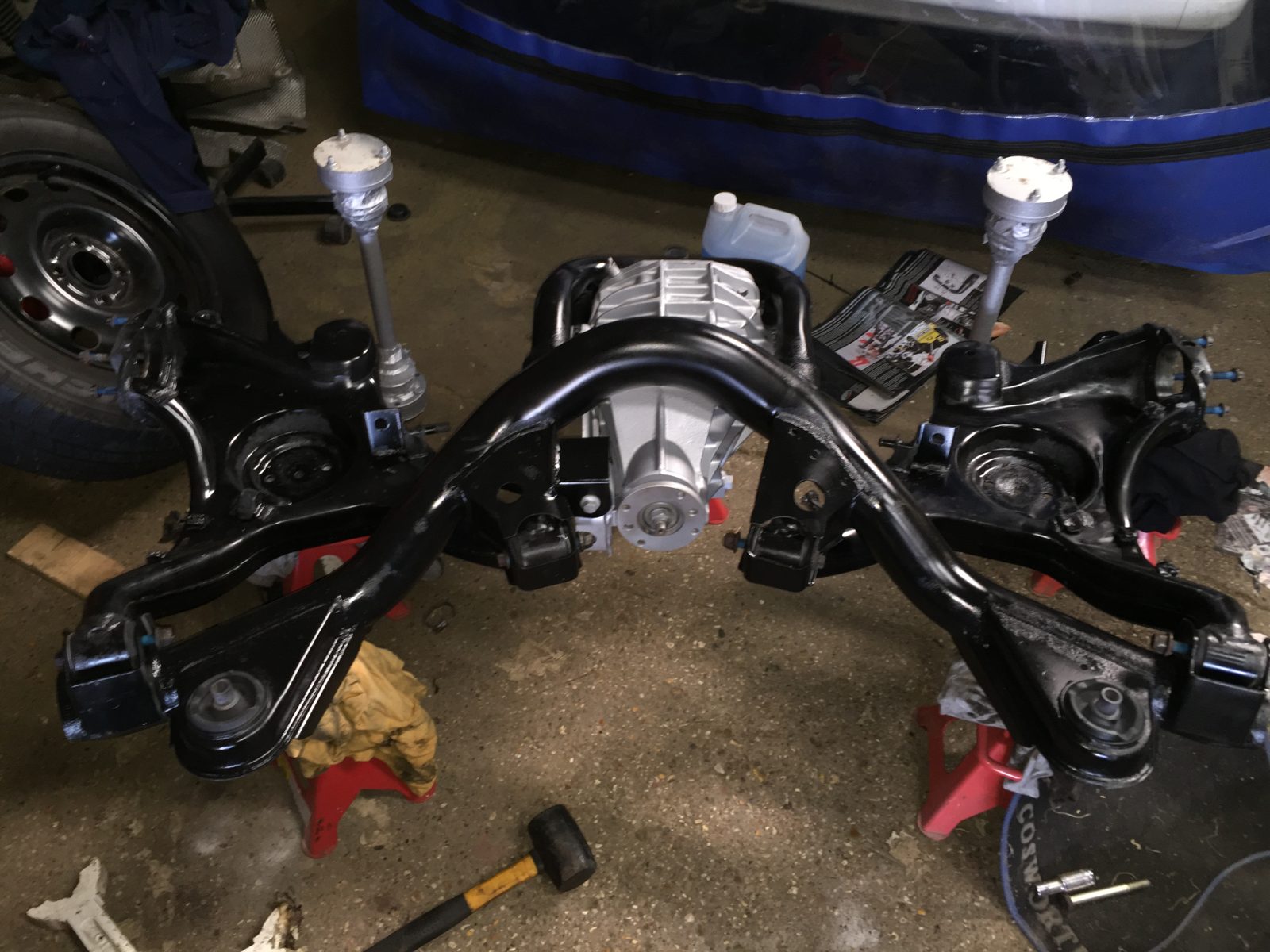 Refurbished rear subframe and differential on the workshop floor, painted black