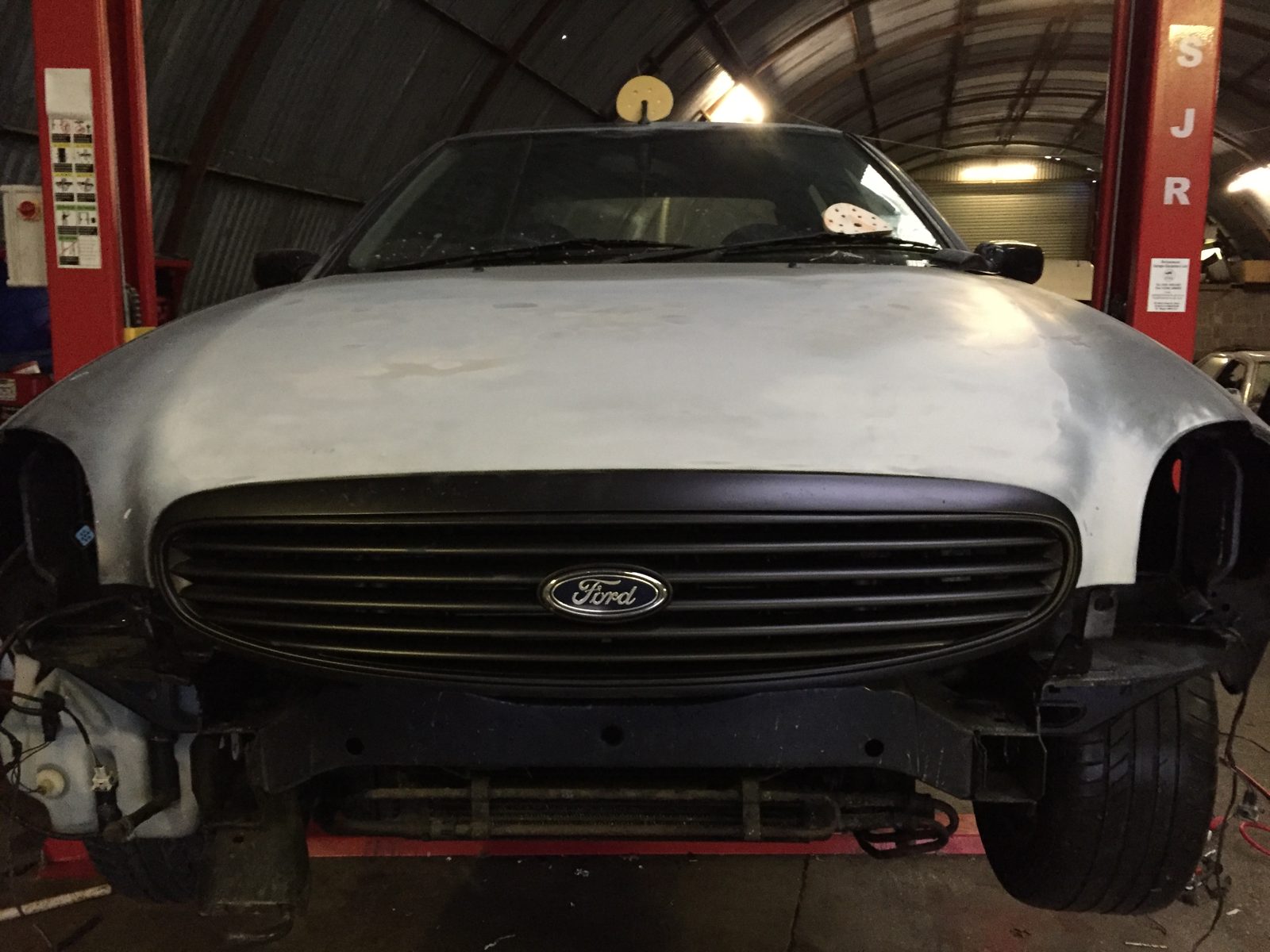 The front end in primer, with the headlights and bumper off