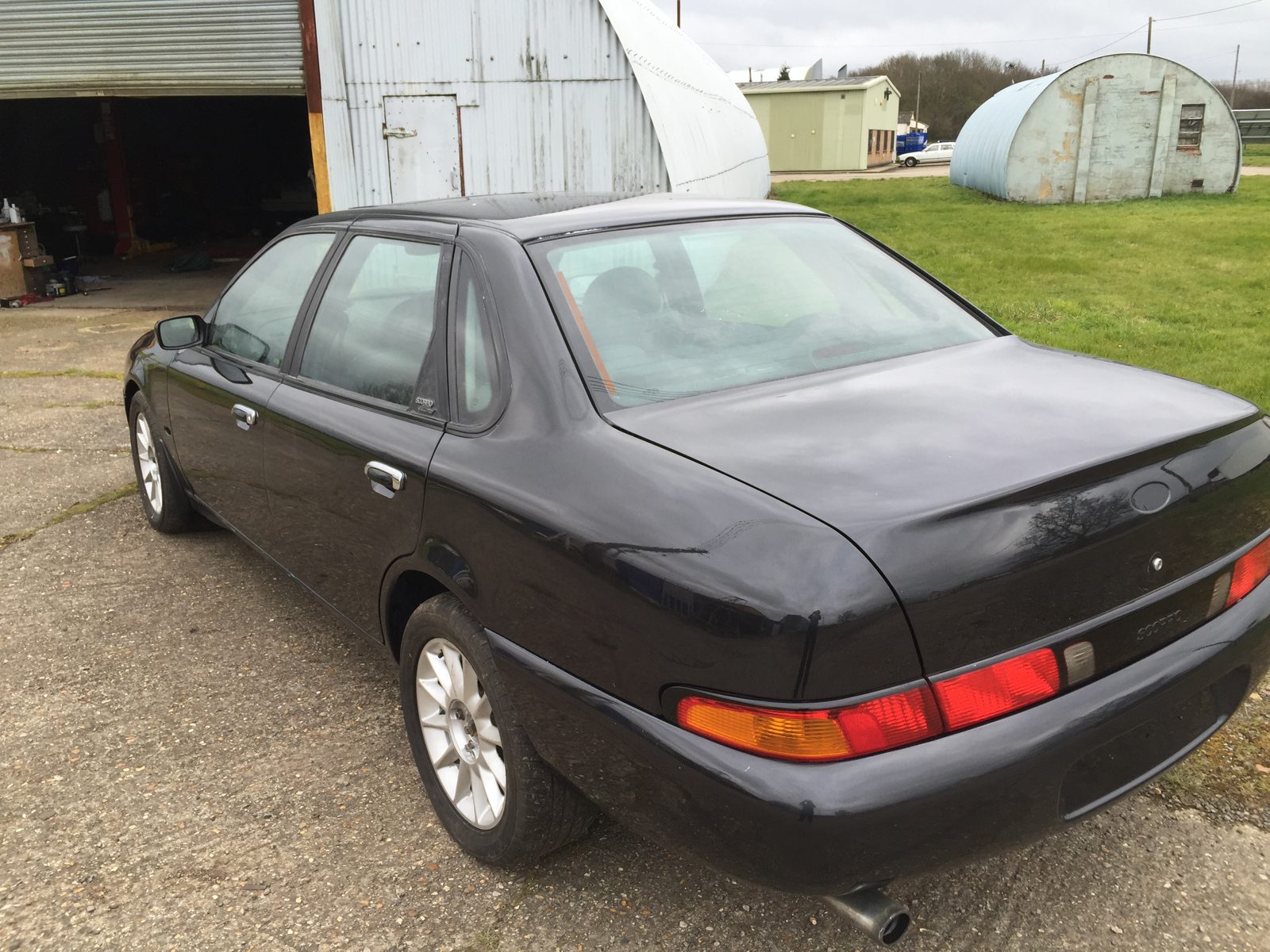 Side profile of the black Granada Scorpio outside the workshop