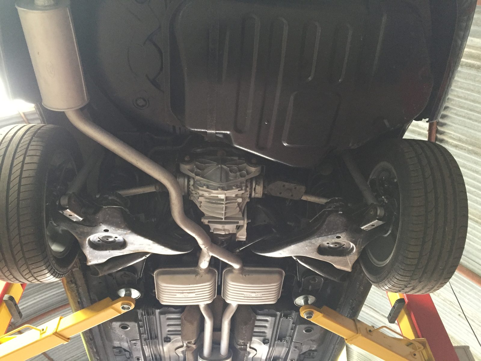 Under the front, with the suspension arms